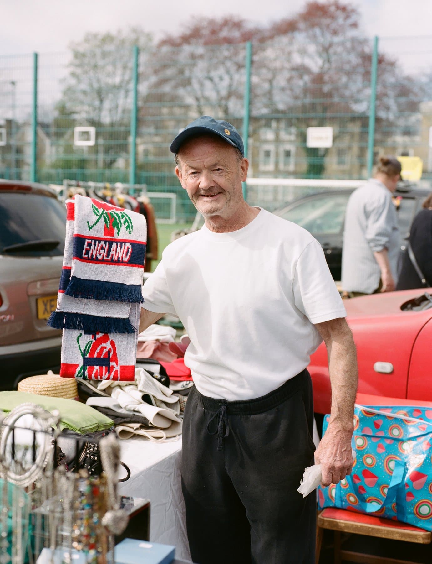 Peckham Carboot seller with cars and second-hand goods. Photography by Betty Oxlade-Martin. Source: https://www.peckhamcarboot.com/gallery