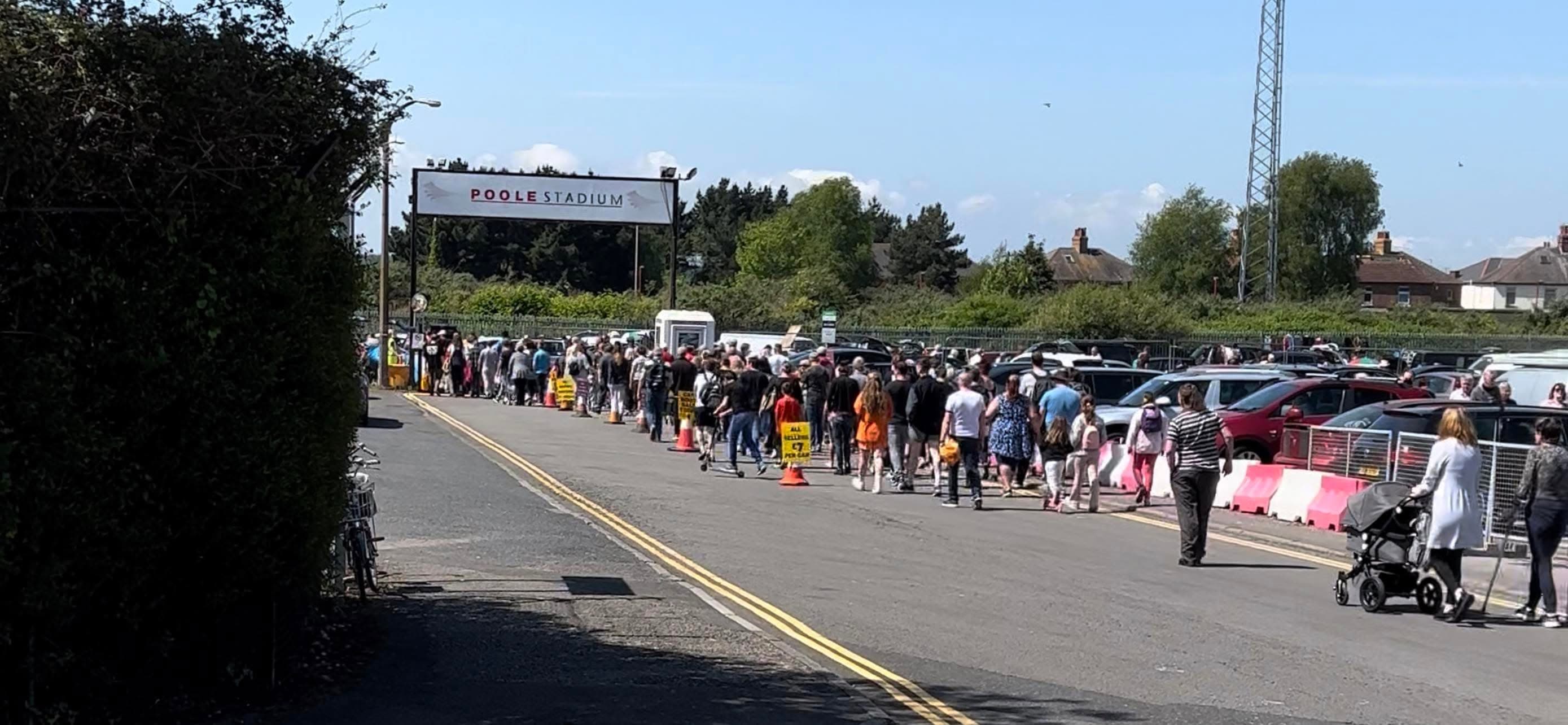 Poole Stadium Car Boot Sale with sellers, parked cars and shoppers at the stadium entrance Source: https://www.facebook.com/photo/?fbid=128617103248038