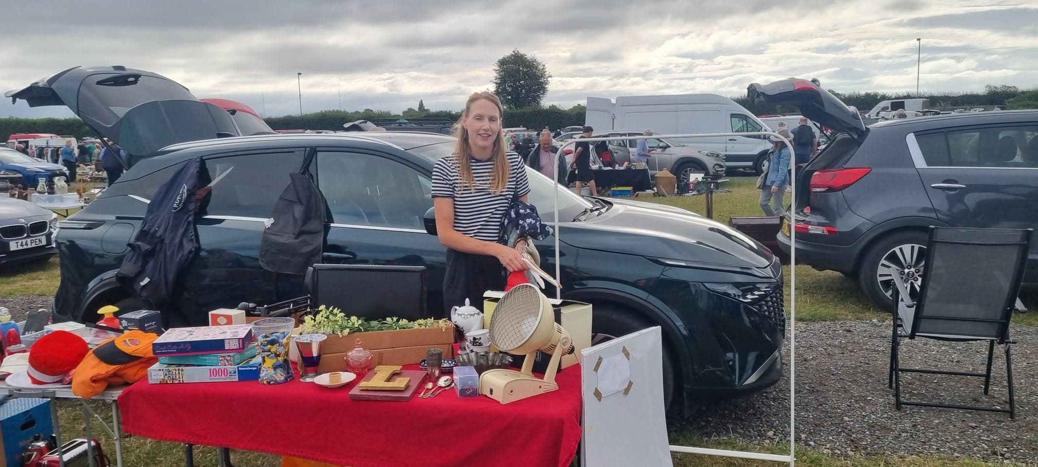A seller behind a table of second-hand goods at York Racecourse Car Boot Source: https://www.facebook.com/photo.php?fbid=1510753067520223