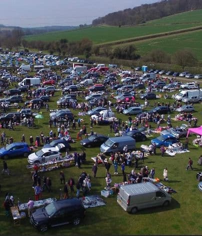 Aerial view of Big Ben's West Wycombe car boot with rows of cars, stalls and shoppers. Source: https://static.wixstatic.com/media/a471b2_76e119686edb4831a37ac2fd87f8e692~mv2.jpg/v1/fill/w_404,h_471,al_c,q_80,enc_avif,quality_auto/a471b2_76e119686edb4831a37ac2fd87f8e692~mv2.jpg