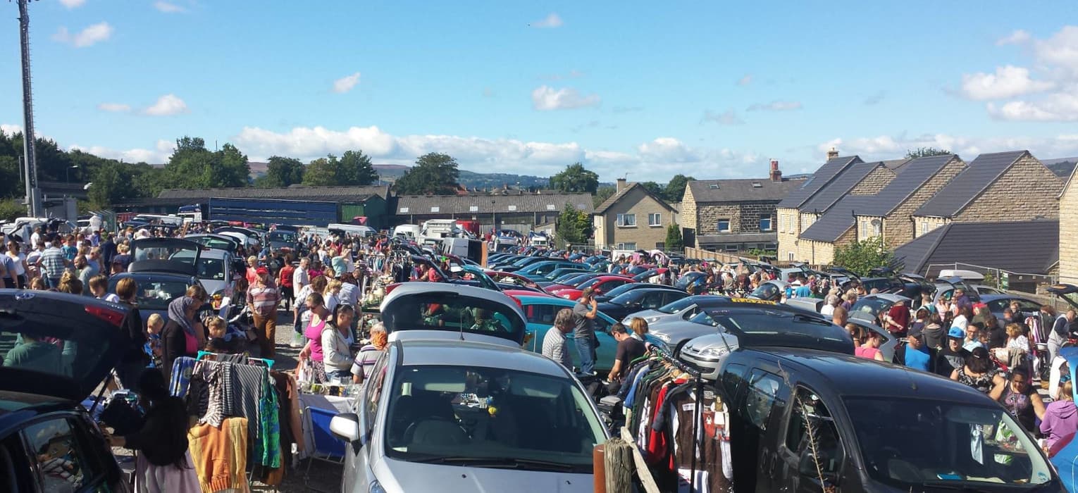 Busy Sunday car boot sale at Otley with rows of cars, stalls and shoppers. Source: https://www.otleycarbootsale.co.uk/wp-content/uploads/2020/09/home_slide1.jpg