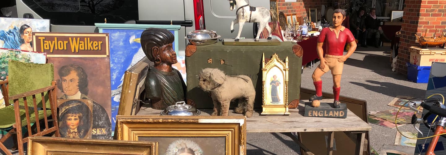 Outdoor antique stalls at Sunbury Antiques Market, Kempton Park, with vans and displayed vintage goods. Source: https://www.sunburyantiques.com/kempton/