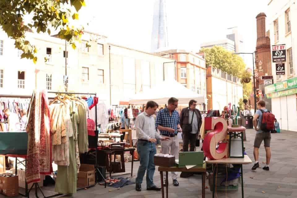 Shoppers browsing vintage clothing and second-hand goods at Flea at Vinegar Yard near London Bridge. Source: https://www.fleamarketinsiders.com/best-flea-markets-london/