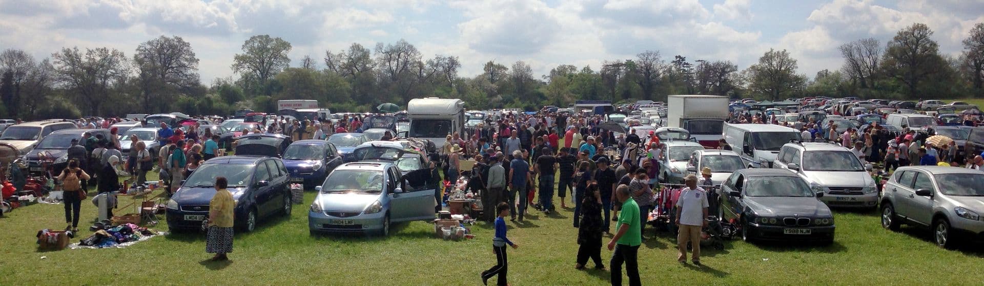 Busy Potters Bar Boot Sale field with rows of cars, stalls and shoppers. Attribution: Potters Bar Boot Sale. Source: https://www.pbcarbootsale.co.uk/