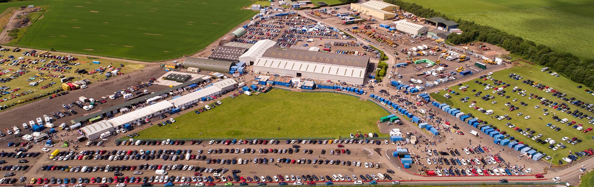 Aerial view of Errol Sunday Market and Car Boot Sale with rows of cars, stalls and shoppers across Errol Airfield. Source: https://d1ssu070pg2v9i.cloudfront.net/pex/errolsundaymarket/2019/06/17142424/M0hMby8o_jpeg.jpg