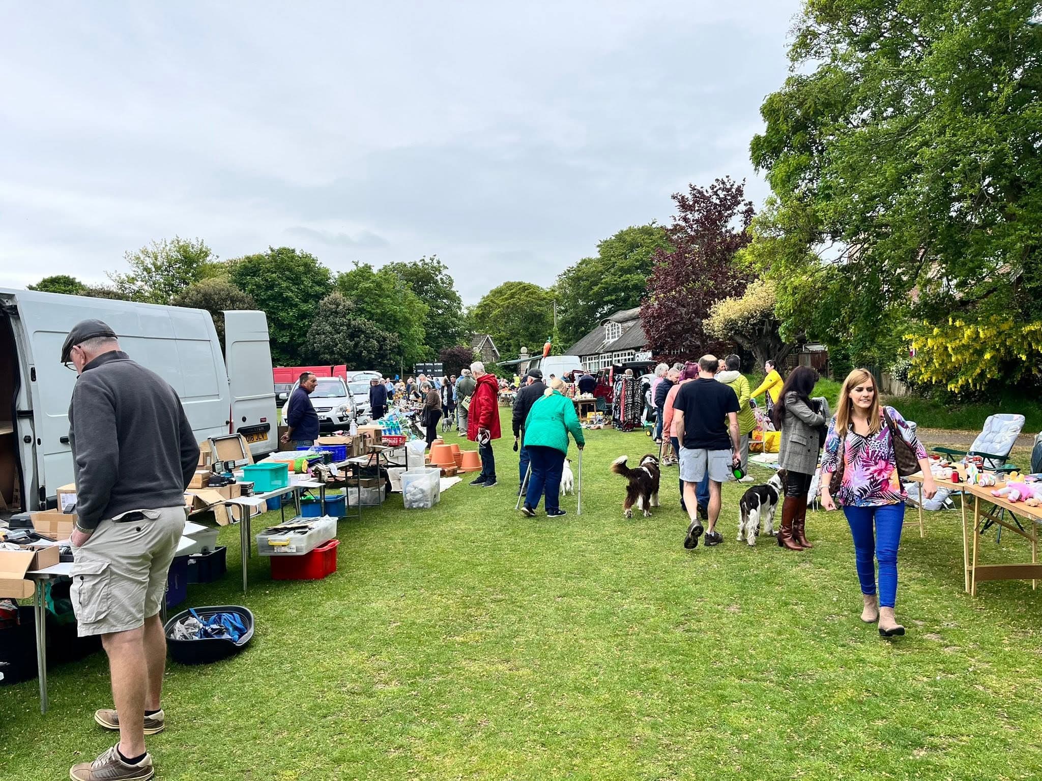 Shoppers browse tables beside cars and vans at Overstrand Sports Ground car boot sale. Source: https://www.facebook.com/photo/?fbid=122193098834798416&set=pb.61573952487717.-2207520000