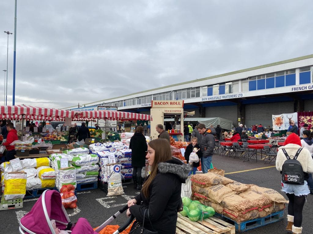 Shoppers browsing produce and general stalls at Bristol Sunday Market