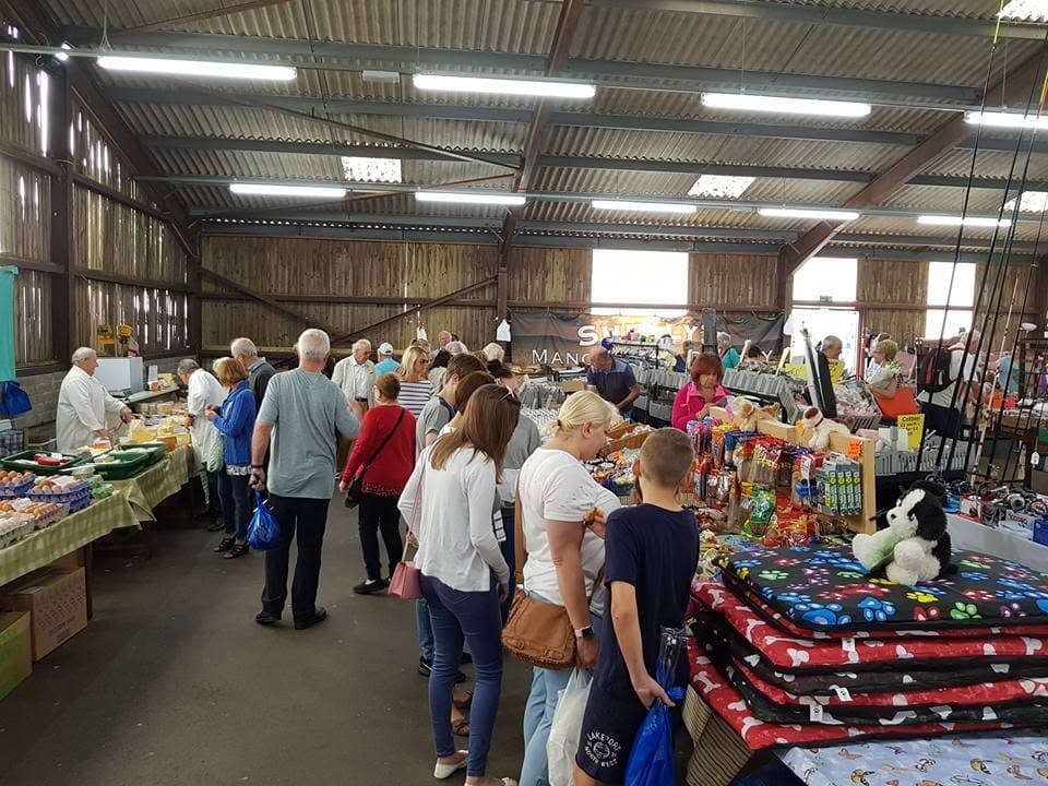 Shoppers browsing busy indoor stalls at Dorchester Market
