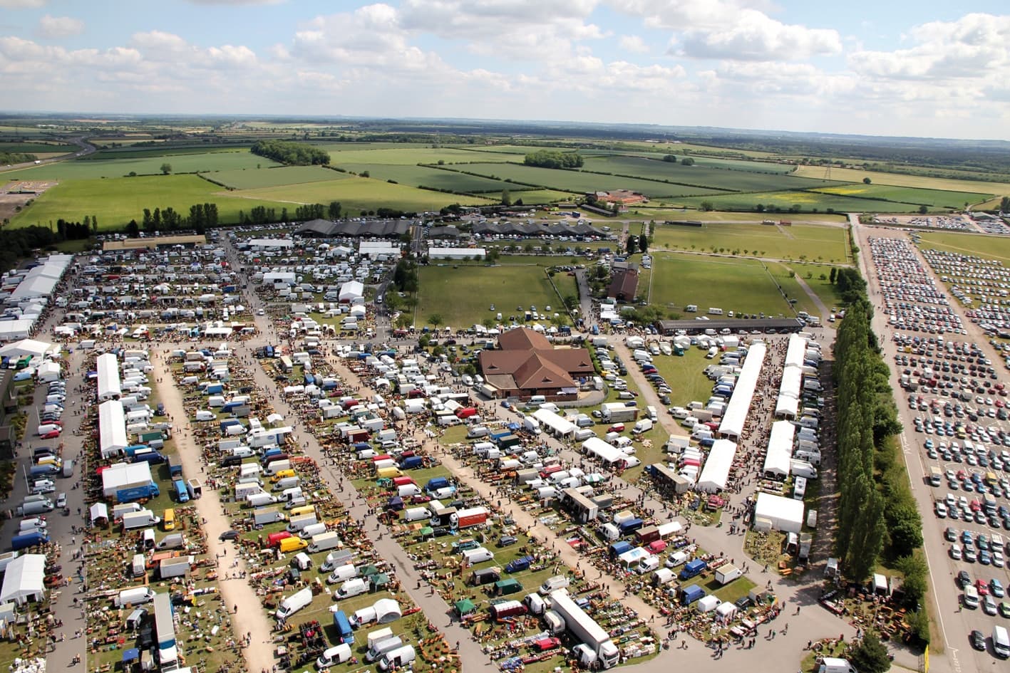 Aerial view of Newark International Antiques and Collectors Fair with extensive rows of stalls, vehicles and visitors Source: https://www.iacf.co.uk/wp-content/uploads/2023/05/Newark-Overview-SMALL-2-1.jpg