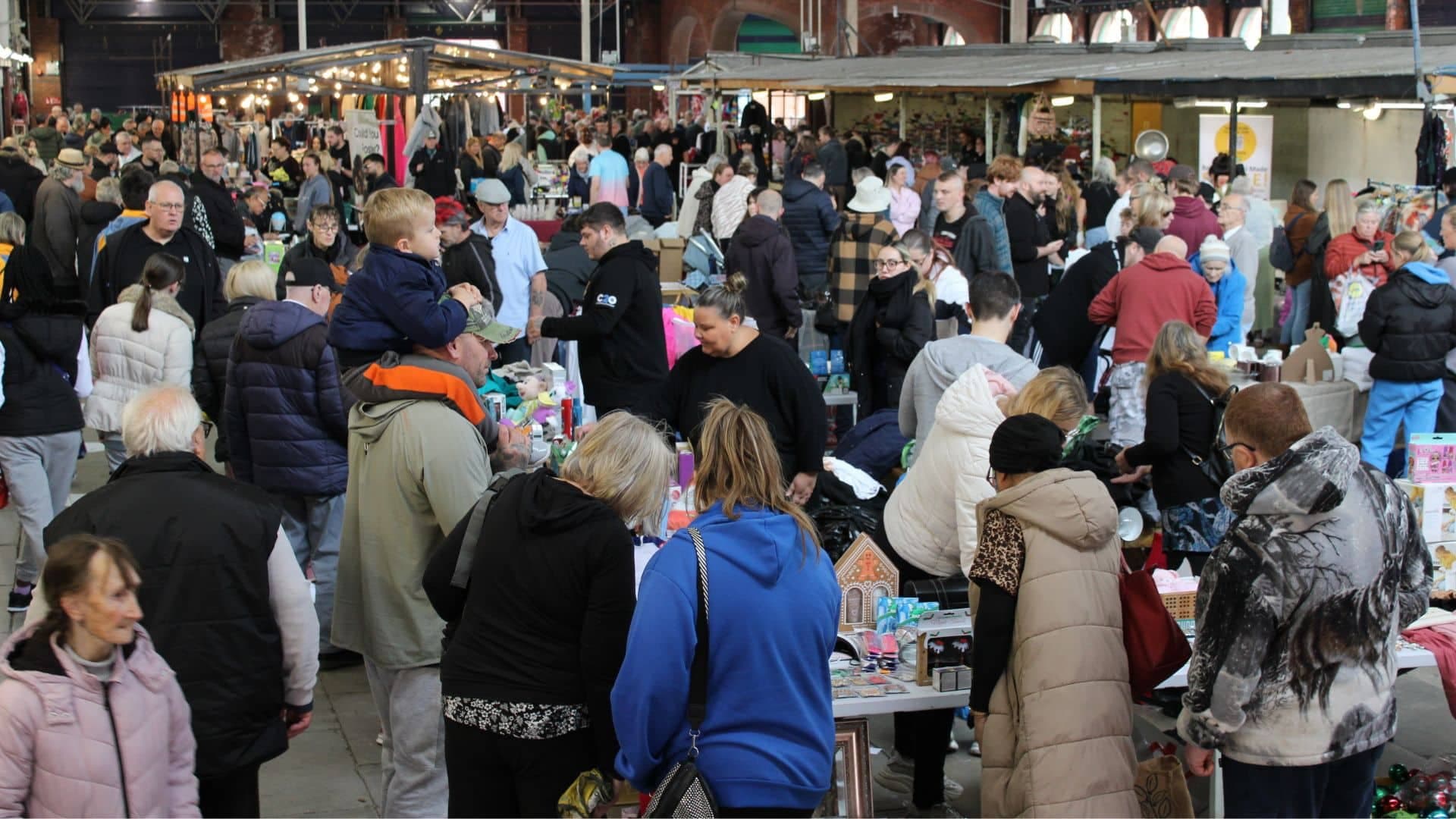 Crowds browsing tables of second-hand goods at Birkenhead Market's covered indoor car boot. Source: https://birkenheadmarket.co.uk/wp-content/uploads/Website-main-feature-9-1.jpg