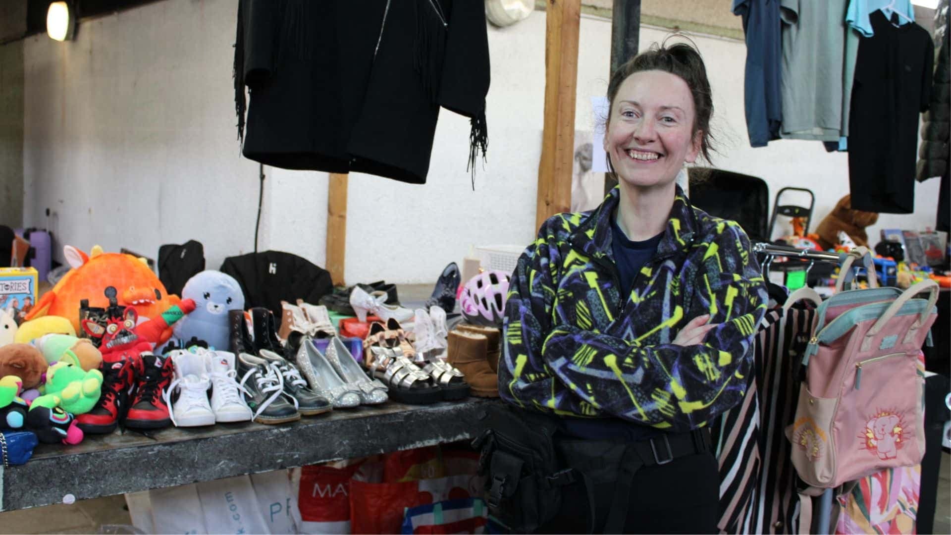 A seller with shoes, toys and bags at Birkenhead Market's indoor car boot. Source: https://birkenheadmarket.co.uk/wp-content/uploads/Website-main-feature-8-1.jpg